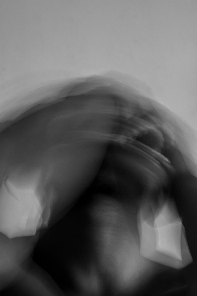 Whirl of Anxiety: When Your Life Stops Feeling Like Yours blurred black-and-white figure in distress symbolizing signs you sold your soul to fear and hustle