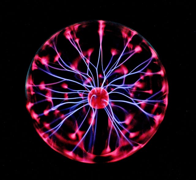 Plasma globe with pink and blue electric filaments on a black background, symbolizing the power to bend the reality
