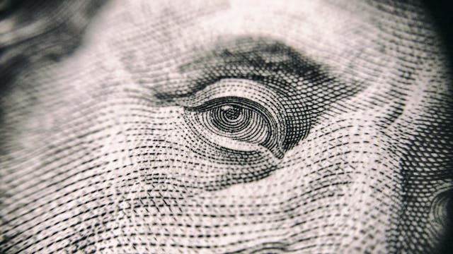 Money’s Stare: The Cost of Chasing Status extreme close-up of a dollar bill eye representing signs you sold your soul to materialism