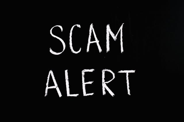 White chalk text on a black background reading “Scam Alert,” symbolizing how subconscious blocks can trick the mind with limiting beliefs and false fears.