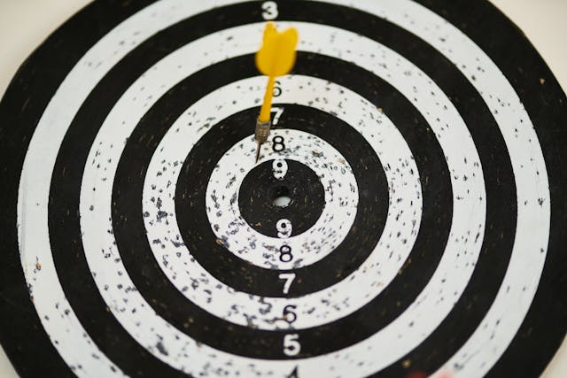 Yellow dart hitting the center of a black and white target, symbolizing focus and the 5 most powerful mantras for success