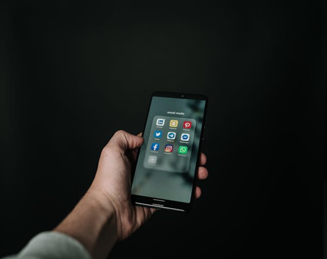 Mindful Digital Energy Hand holding smartphone with social media apps on screen
