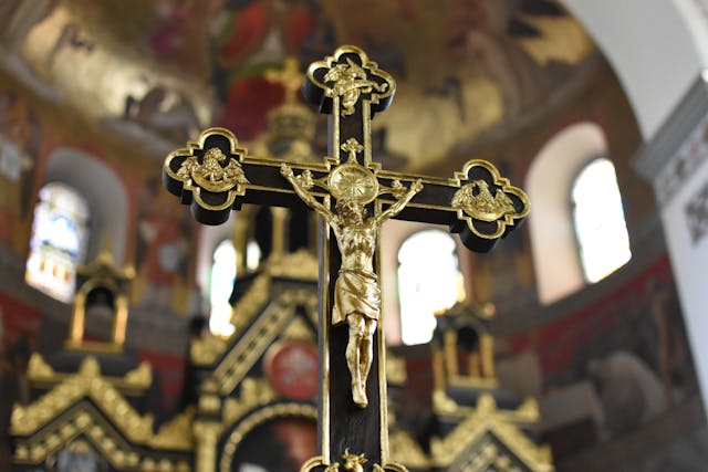 Golden Crucifix in Sanctuary Golden crucifix inside an ornate church with soft, blurred altar lights—ask god to guide you.