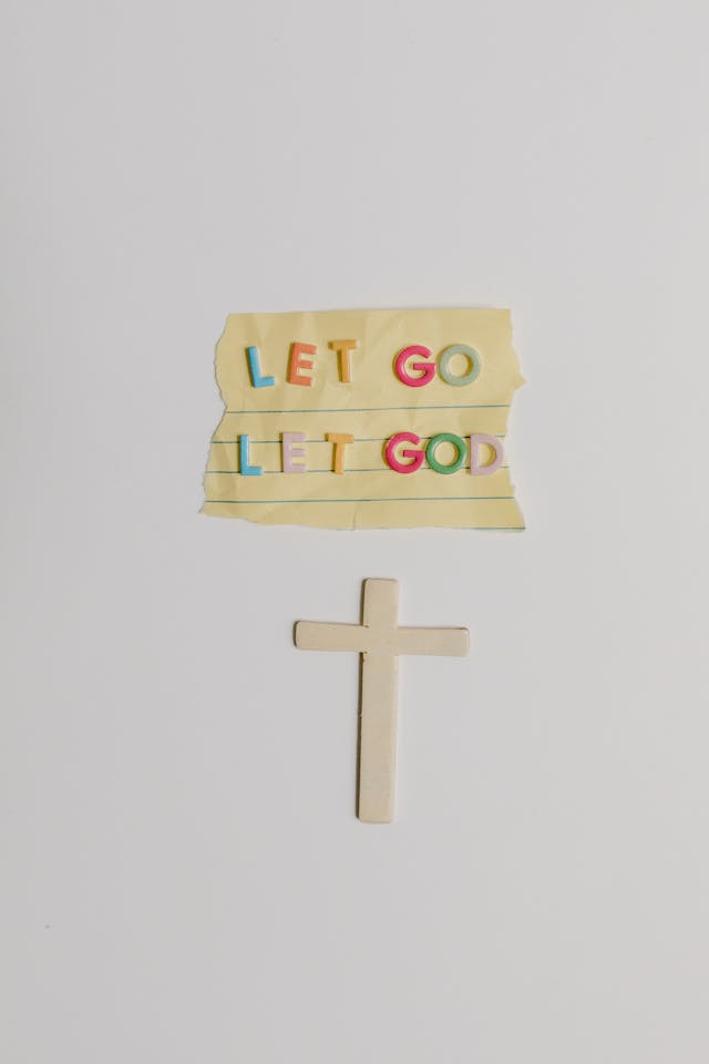 Let Go, Let God Minimalist Cross Minimal flat lay with a small cross and a note reading “Let go, let God” on a white background—ask god to guide you.
