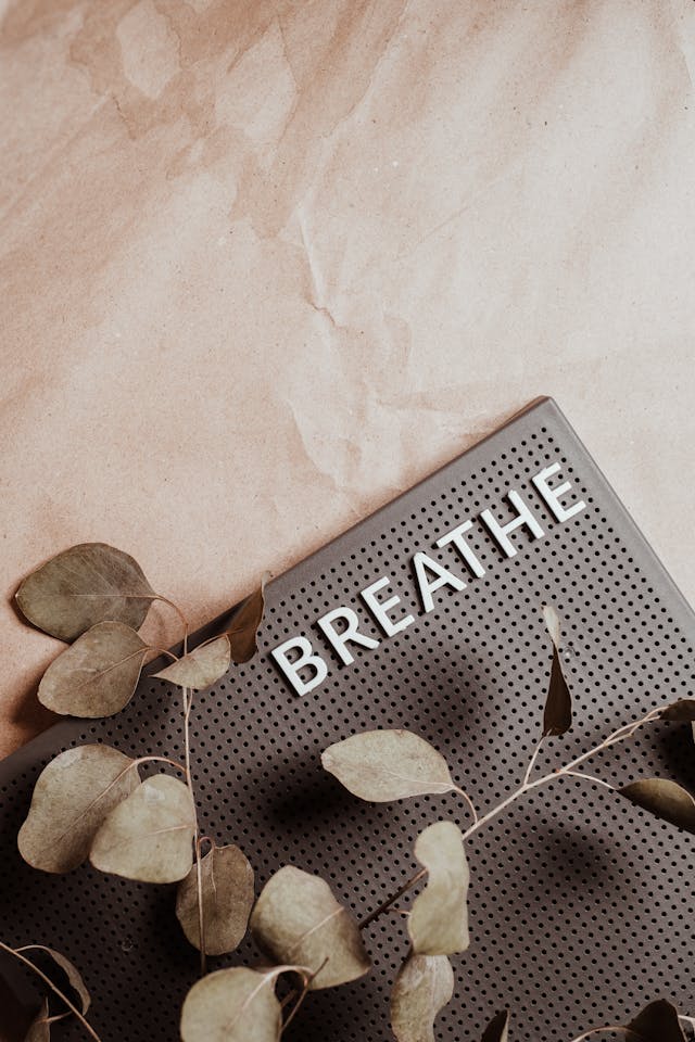 Breathe and Release Control Close-up of the word BREATHE on a textured board with dried leaves