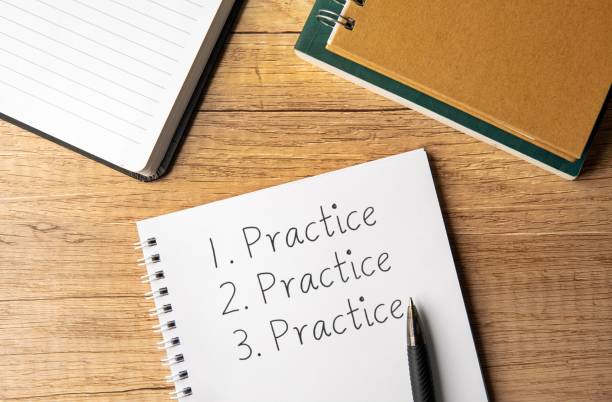 Notebook page listing “Practice” three times beside a pen on a wooden desk, emphasizing repetition for hypnosis to get rich.