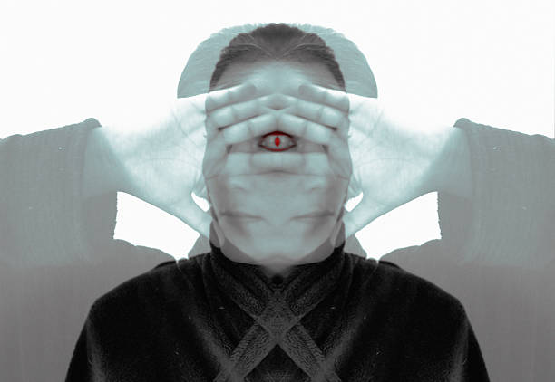 Surreal mirrored image of a person covering their face with hands, revealing a symbolic third eye at the center to represent third eye chakra opening symptoms.